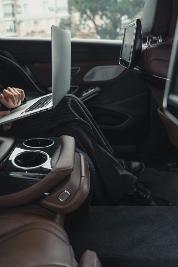 Image of a woman using a laptop in a car